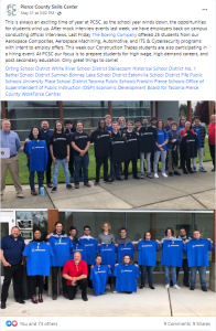 Core Plus Aerospace students, teachers and Boeing leadership standing in front of a table after accepting a job offer from Boeing.