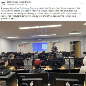 A social media post with an image of a person giving a presentation to a classroom of students. 