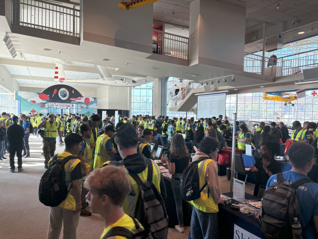 A photo of a group of people attending a career fair in a museum setting.